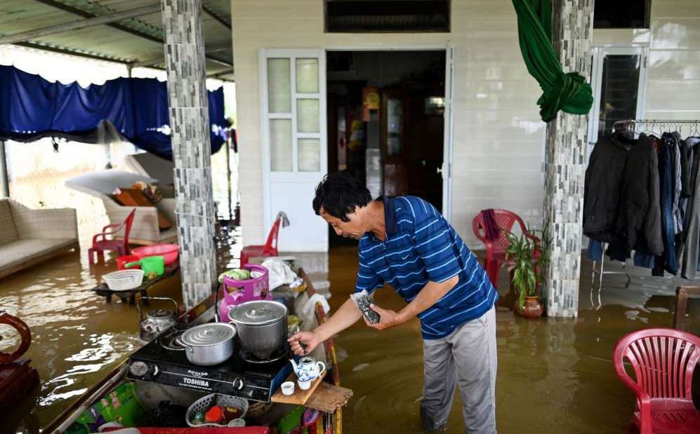 24h qua ảnh: Người đàn ông pha trà trong ngôi nhà ngập lụt ở Việt Nam