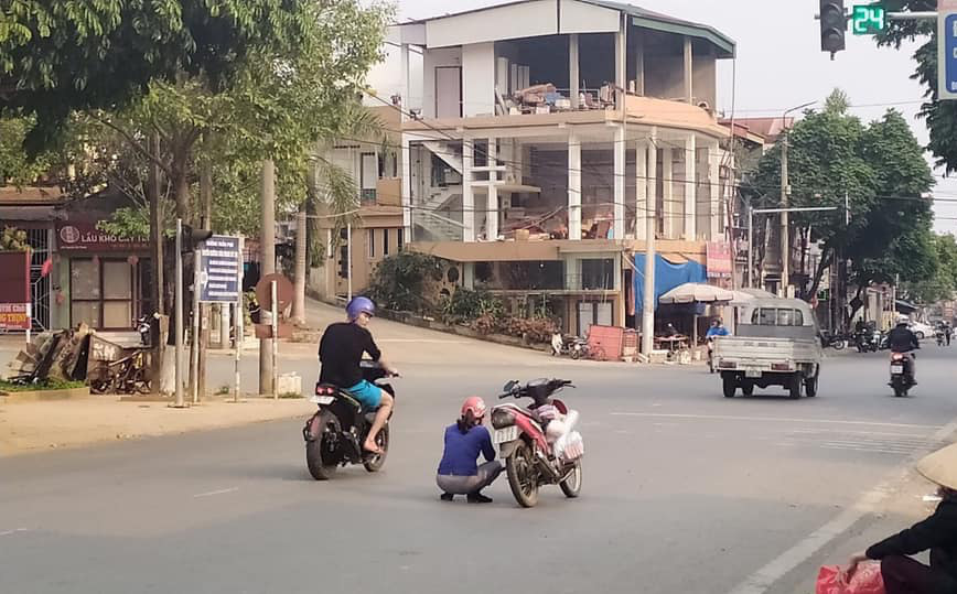 Người phụ nữ dừng xe máy ngồi giữa đường, hành động sau đó của chị khiến ai cũng kinh ngạc