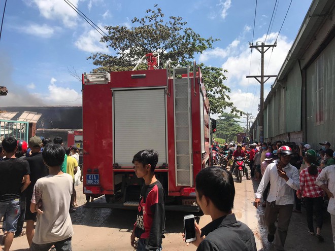 Hàng trăm người dân bất chấp nguy hiểm, đứng xem cháy công ty gỗ dưới đường điện cao thế - Ảnh 2.