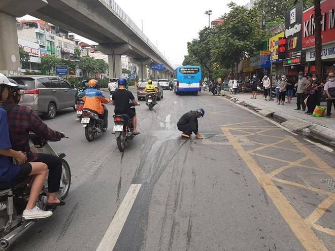 Lỡ đổ dầu ra đường, người đàn ông lớn tuổi cặm cụi ngồi lau khiến dân mạng nhấn like rần rần - Ảnh 1.