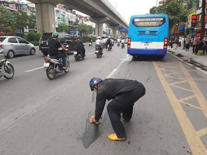 Lỡ đổ dầu ra đường, người đàn ông lớn tuổi cặm cụi ngồi lau khiến dân mạng nhấn like rần rần - Ảnh 2.