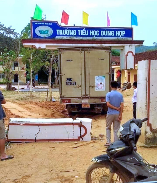 Xe tải chở sữa đâm sập cổng trường tiểu học, một phần cổng lơ lửng trên thùng xe - Ảnh 1.
